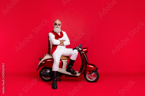 Full length body size view of his he nice attractive well-groomed stylish trendy content virile gray-haired man sitting on bike folded arms isolated over bright vivid shine red background