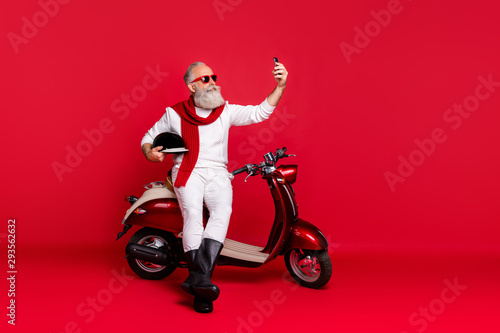 Portrait of his he nice attractive stylish trendy confident content gray-haired man holding in hands phone taking making selfie isolated over bright vivid shine red background