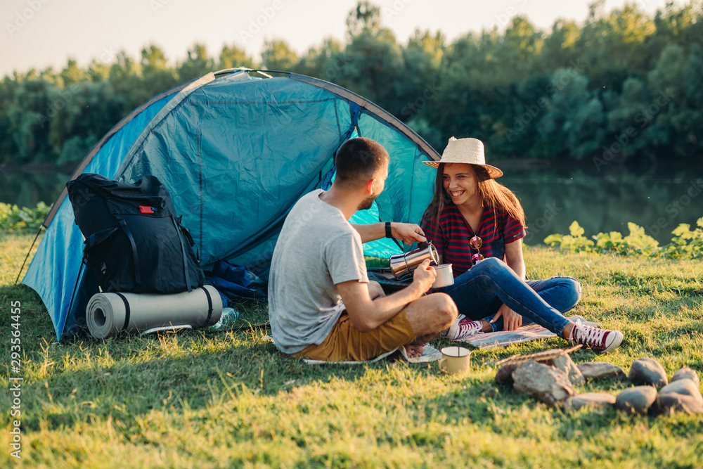 friends on camping outdoor by the lake or river - obrazy, fototapety, plakaty 