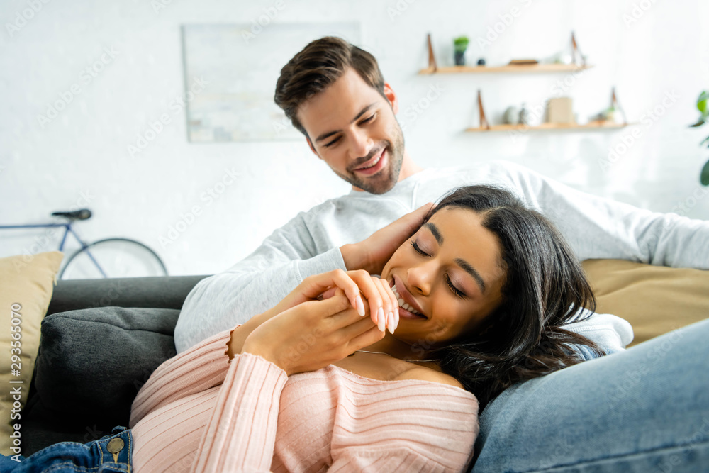 african american woman and handsome man smiling and hugging in apartment african american woman and handsome man smiling and hugging in apartment