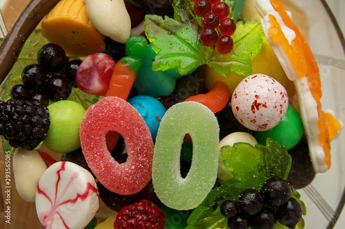 Foto Delicious marmalade sweets of different shapes lie in a glass vase
