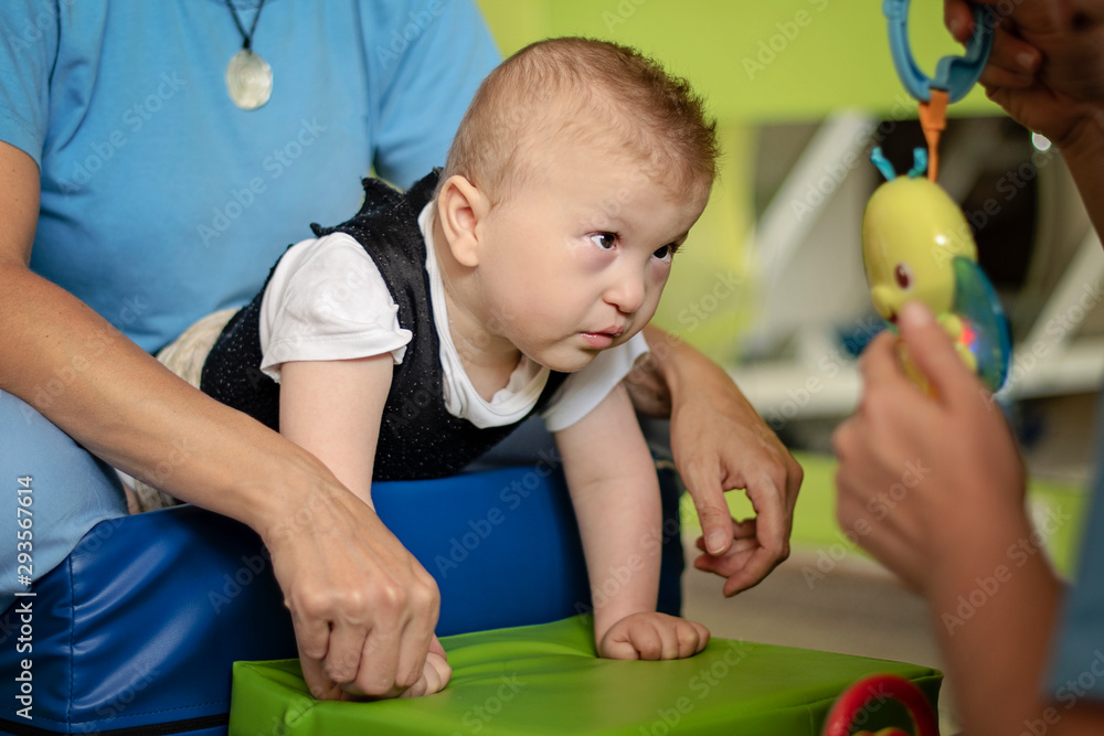 Portrait of a baby with cerebral palsy on physiotherapy in a children