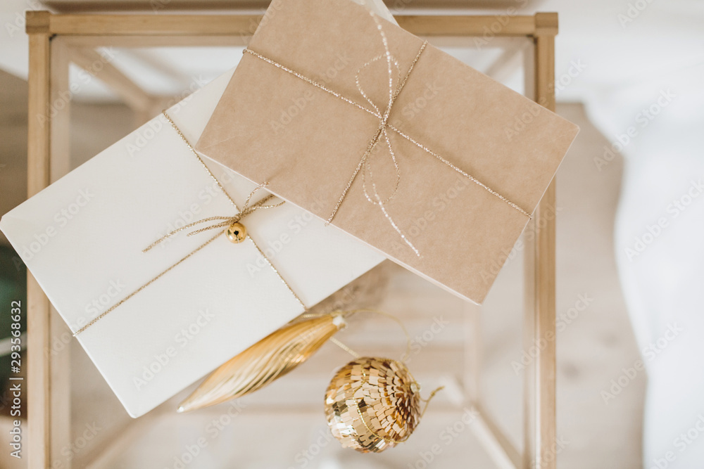 Christmas, New Year background with craft gift boxes and golden Christmas balls. Minimal winter holidays festive composition. Flat lay, top view Christmas, New Year background with craft gift boxes and golden Christmas balls. Minimal winter holidays festive composition. Flat lay, top view