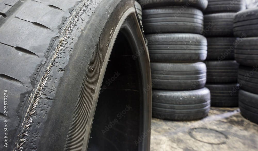Irregular Tire Wear , Damaged black tire of side wear area on blurred pile old tyres background. Irregular Tire Wear , Damaged black tire of side wear area on blurred pile old tyres background.