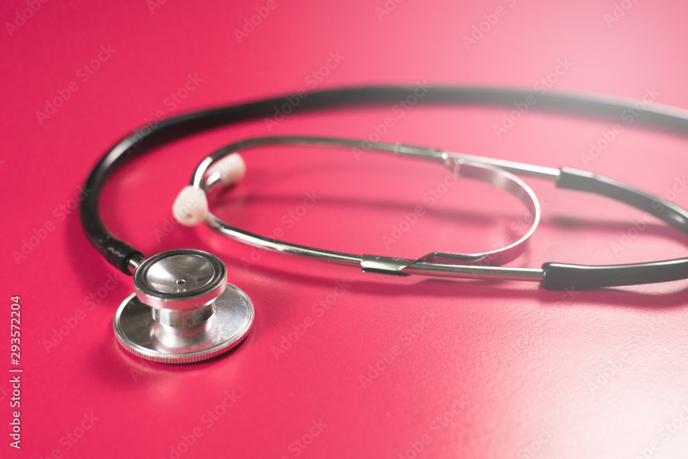 Stethoscope on a pink table. Concept of a medical examination and health care Stethoscope on a pink table. Concept of a medical examination and health care