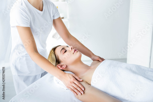 cropped view of masseur doing hand massage to attractive woman