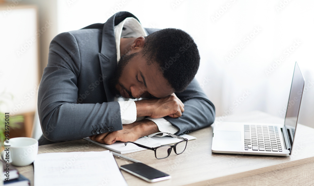 Tired african american businessman having a nap at workplace Tired african american businessman having a nap at workplace