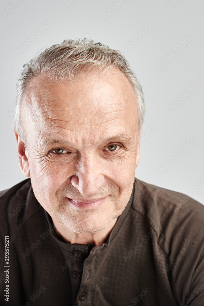 Portrait of a Caucasian elderly man smiling on a white studio background. Handsome gray-haired old pensioner with a friendly kind face Portrait of a Caucasian elderly man smiling on a white studio background. Handsome gray-haired old pensioner with a friendly kind face