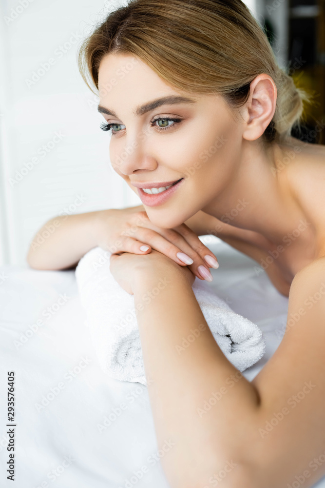 attractive and smiling woman lying on massage mat in spa attractive and smiling woman lying on massage mat in spa