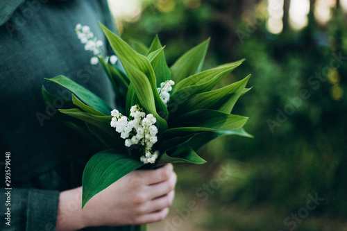 Bouquet of lilies of the valley in children's hands