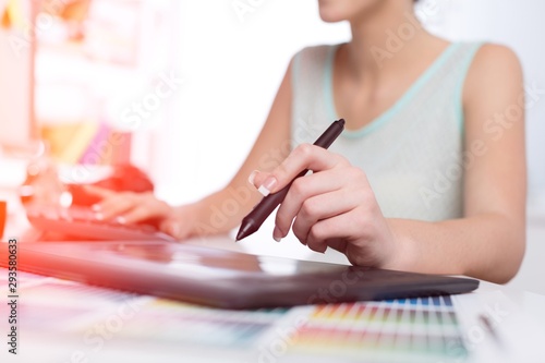 Hand of the designer with a pen on a tablet photo