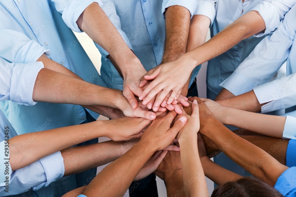 Group of people stacking hands together Group of people stacking hands together