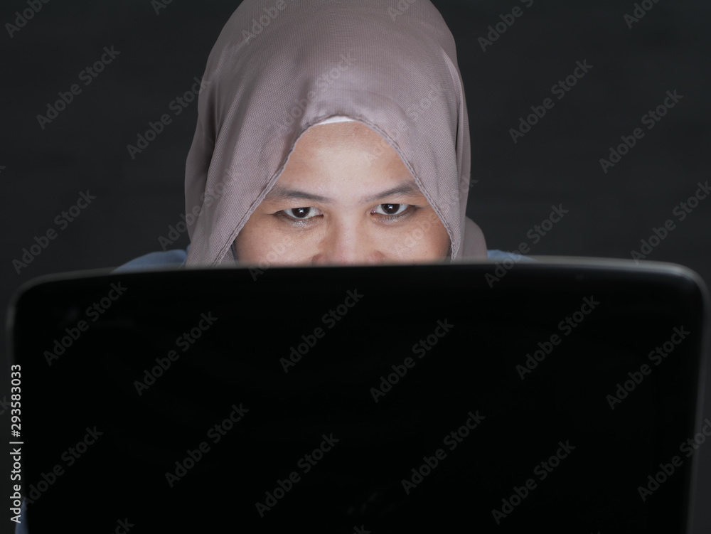 Muslim Woman With Cunning Look on Laptop Muslim Woman With Cunning Look on Laptop