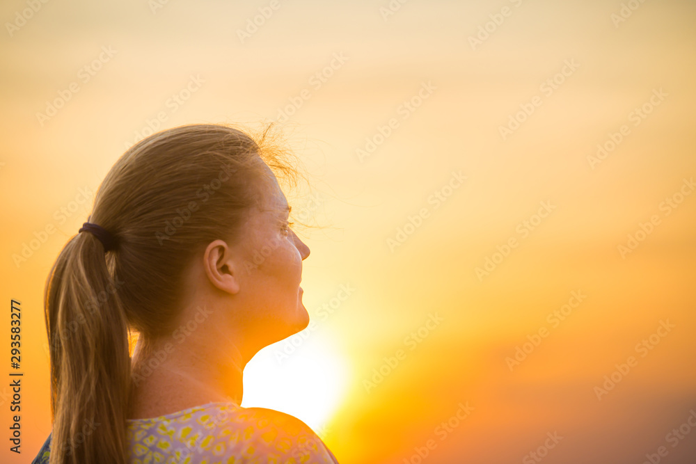 Silhouette of young woman looking to beautiful yellow sunset Silhouette of young woman looking to beautiful yellow sunset