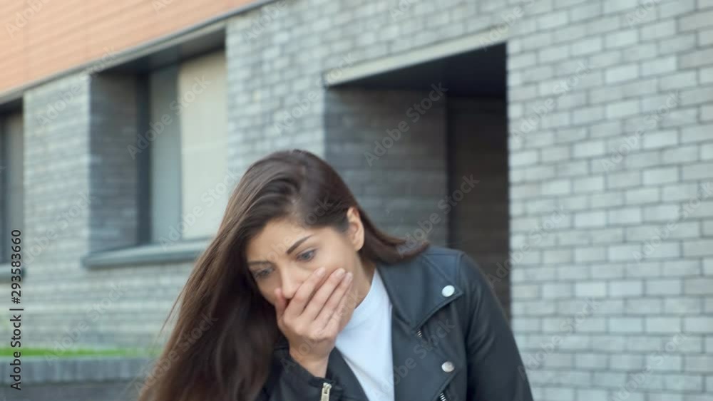 A young woman is talking on the phone and drops it. She is terrified, the smartphone crashed A young woman is talking on the phone and drops it. She is terrified, the smartphone crashed