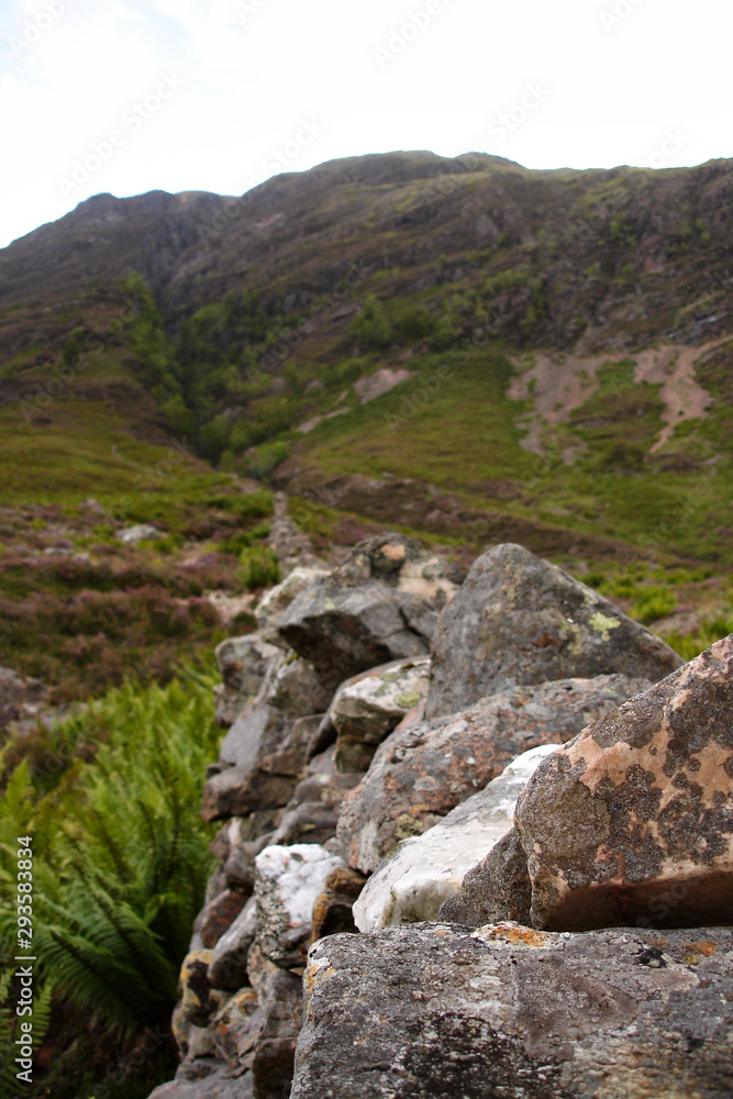 View along a stone wall towards mountains in Scotland