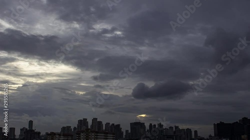 Dramatic cumulus clouds time lapse moving over the silhouette skylines photo