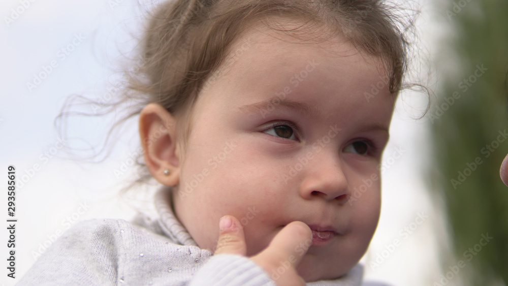 Portrait of cute little girl smiling with finger in mouth outdoors Portrait of cute little girl smiling with finger in mouth outdoors