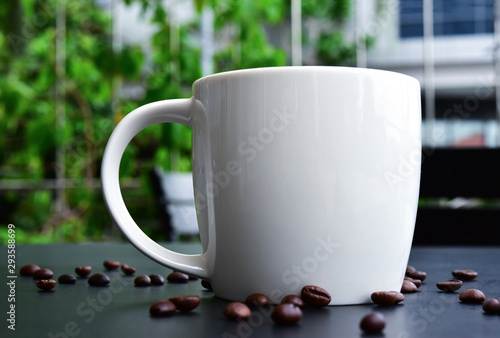 Cap of Coffee on the of dark wood table have many coffee beans. photo