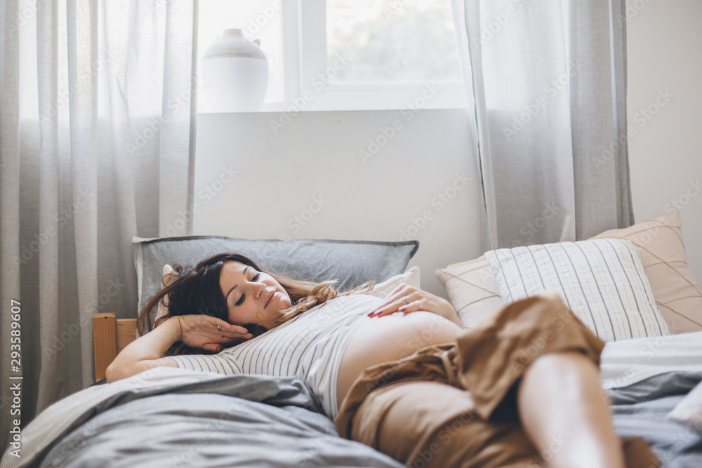 Pregnant woman reading book on bed Pregnant woman reading book on bed