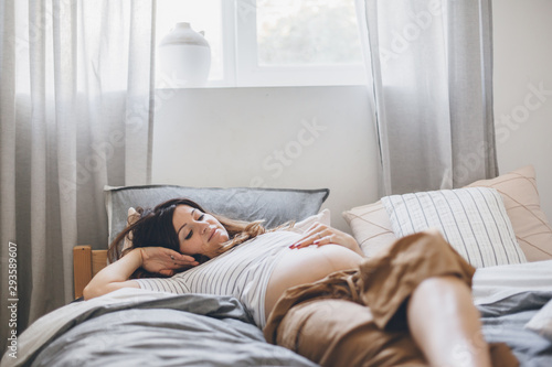 Pregnant woman reading book on bed
