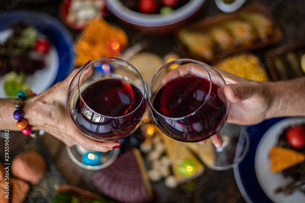 Family Christmas dinner for a celebration with red wine and cheers Family Christmas dinner for a celebration with red wine and cheers