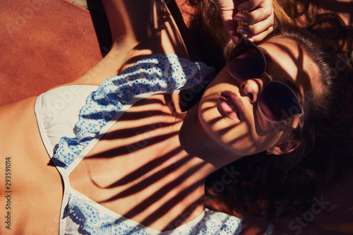 Cool girl sunbathing in bikini top and shadows photo