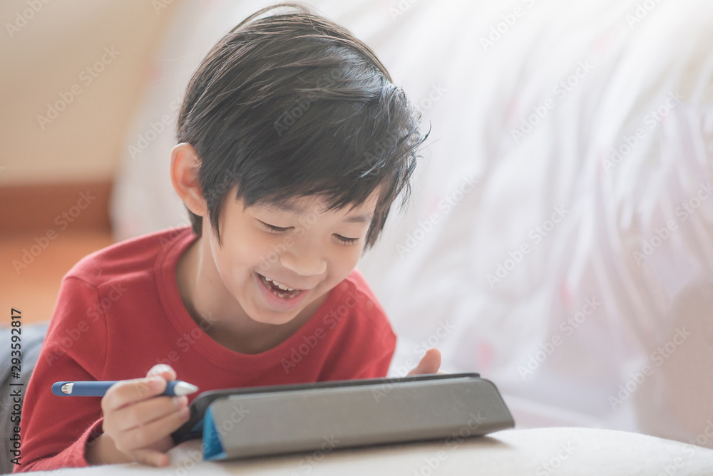 Asian child drawing picture with digital pen on tablet pc computer Asian child drawing picture with digital pen on tablet pc computer