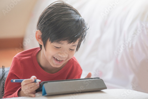 Asian child drawing picture with digital pen on tablet pc computer