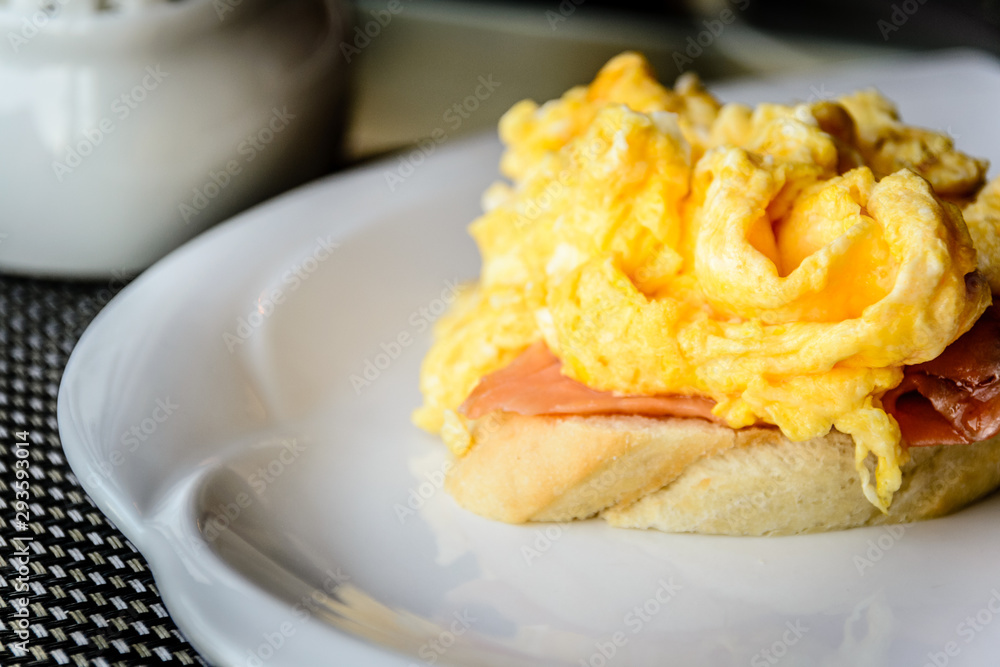 scrambled eggs on smoked salmon and baguette served on a white china plate
