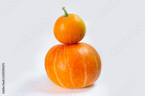 two orange pumpkins on top of each other on an isolated background