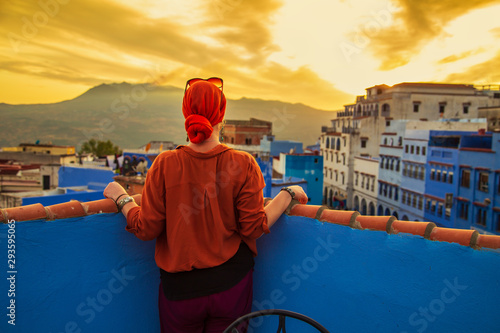 Girl looks at the famous blue city from above. Sunset. © lizavetta