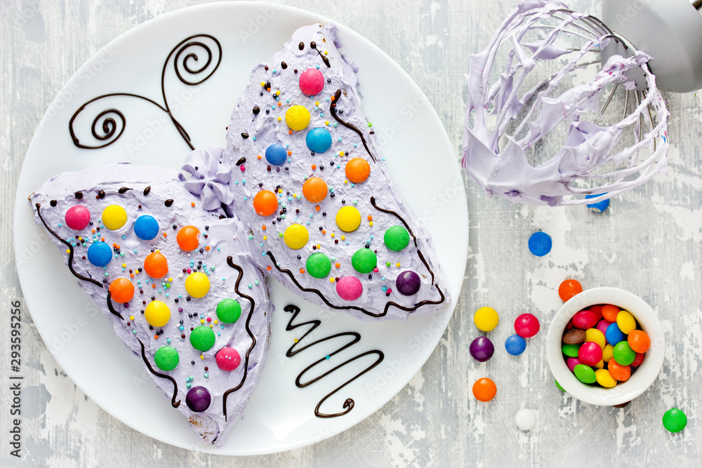 Butterfly cake - delicious homemade cake shaped colorful butterfly decorated with cream, chocolate and colored candies