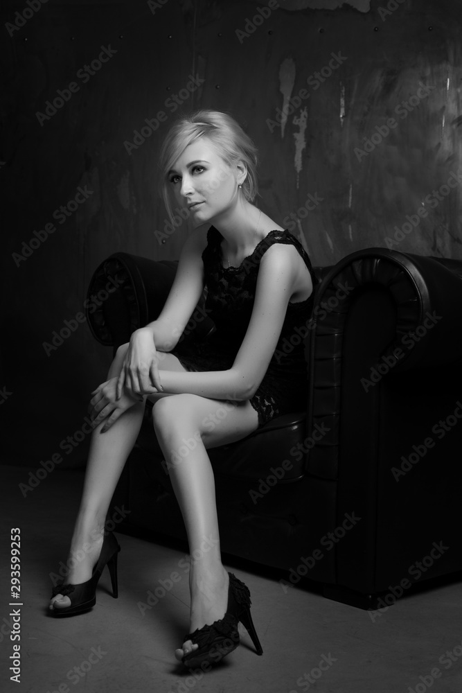 Beautiful young blond woman sitting in a chair Beautiful young blond woman sitting in a chair