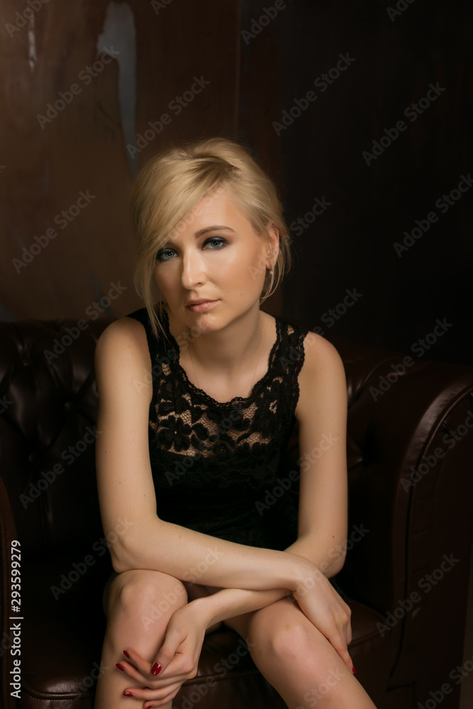 Beautiful young blond woman sitting in a chair Beautiful young blond woman sitting in a chair