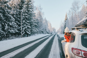 Magic car trip on the road by winter forest covered by snow