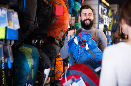 Couple choosing rucksack in store