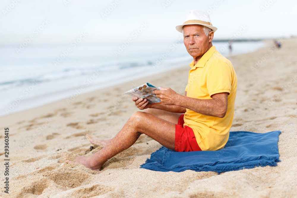 Lucky mature man  sitting and looking at booklet