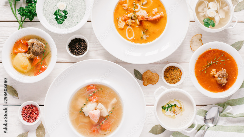Restaurant menu. Top view of plates with soup assortment and seasoning on white wooden table. Restaurant menu. Top view of plates with soup assortment and seasoning on white wooden table.