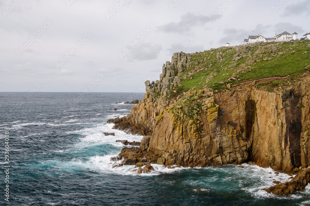 epic ragged rocks and coastline at lands end with rough seas