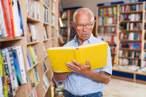 man absorbedly searching for interesting books photo