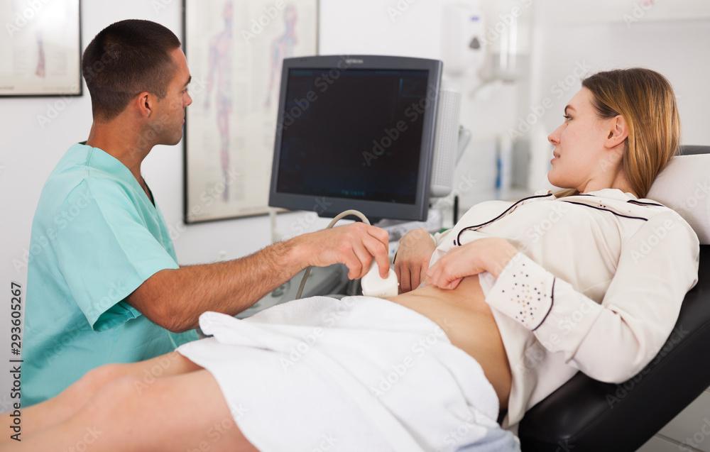 Fototapeta premium Man sonographer examining female patient