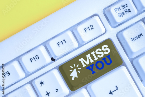 Writing note showing Miss You. Business concept for Longing for an important demonstrating in your life for a period of time White pc keyboard with note paper above the white background photo