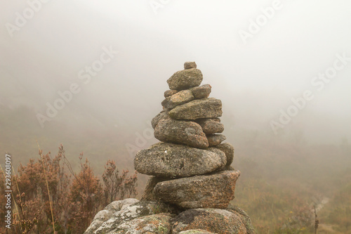 Leinwand Poster Cairn or stone trail marker