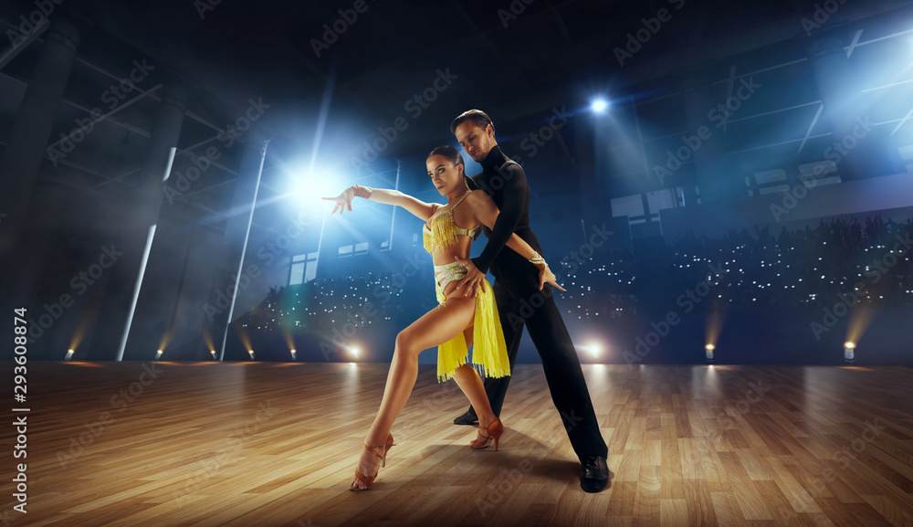 Couple dancers perform latin dance on large professional stage. Ballroom dancing. Couple dancers perform latin dance on large professional stage. Ballroom dancing.