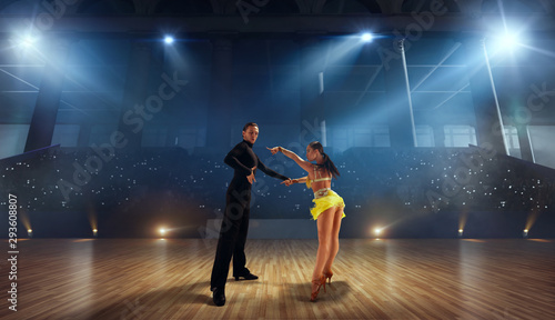 Couple dancers perform latin dance on large professional stage. Ballroom dancing.