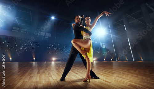 Fototapeta Naklejka Na Ścianę i Meble -  Couple dancers  perform latin dance on large professional stage. Ballroom dancing.