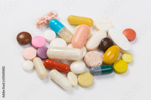 Assorted pharmaceutical medicine pills, tablets and capsules.Heap of assorted various medicine tablets and pills different colors on white background. Top view.Copy space
