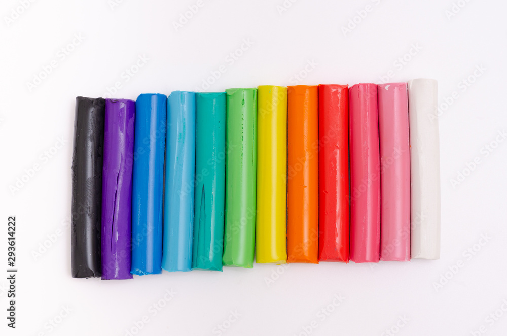 Multi-colored modelling clay stacked on a white background. Multi-colored modelling clay stacked on a white background.