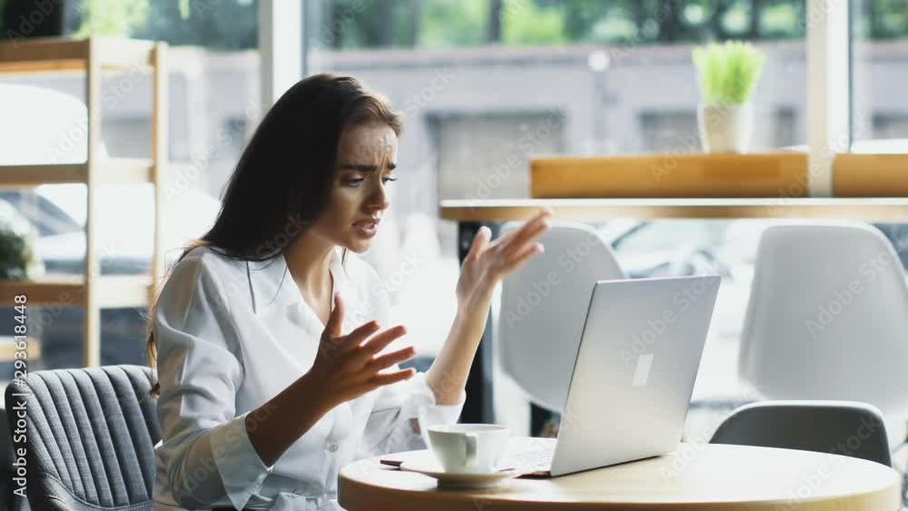 dissatisfied and angry businesswoman sitting in cafe with laptop an dcup of coffee dissatisfied and angry businesswoman sitting in cafe with laptop an dcup of coffee